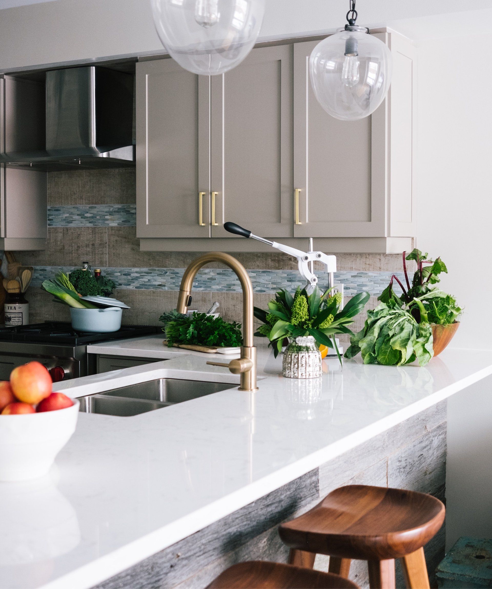 A kitchen with a sink and a bowl of fruit on the counter