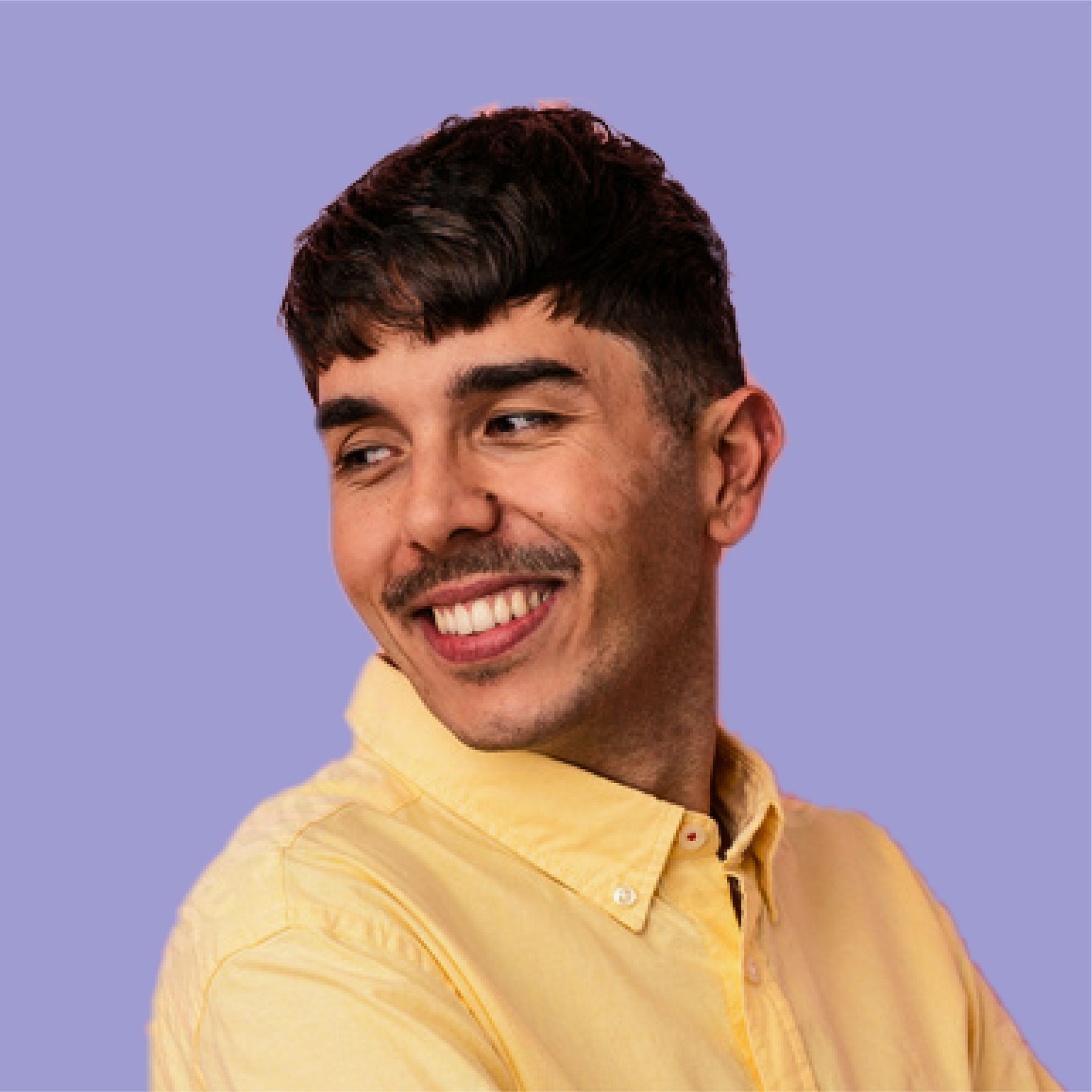 A young man with a mustache is smiling and wearing a yellow shirt.