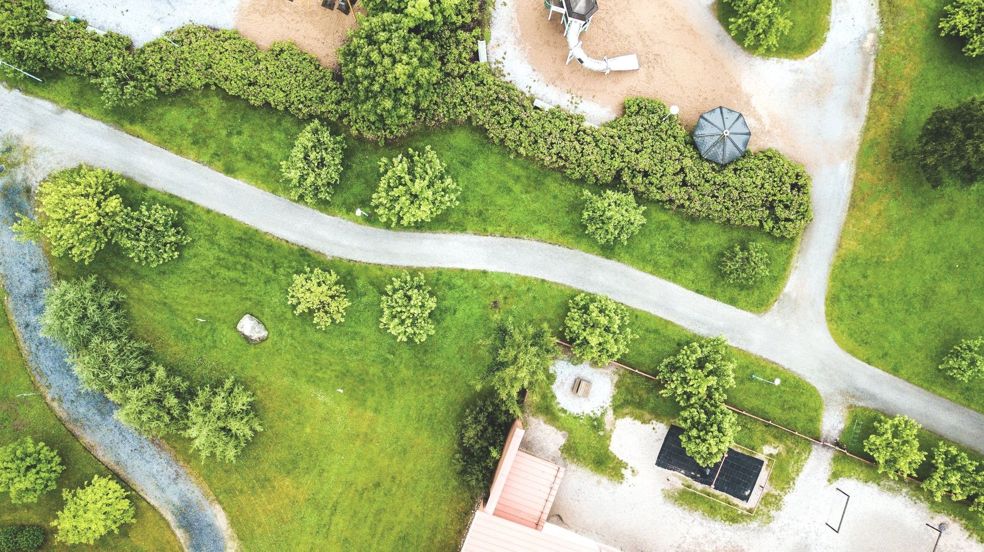 An aerial view of a park with trees and a playground.