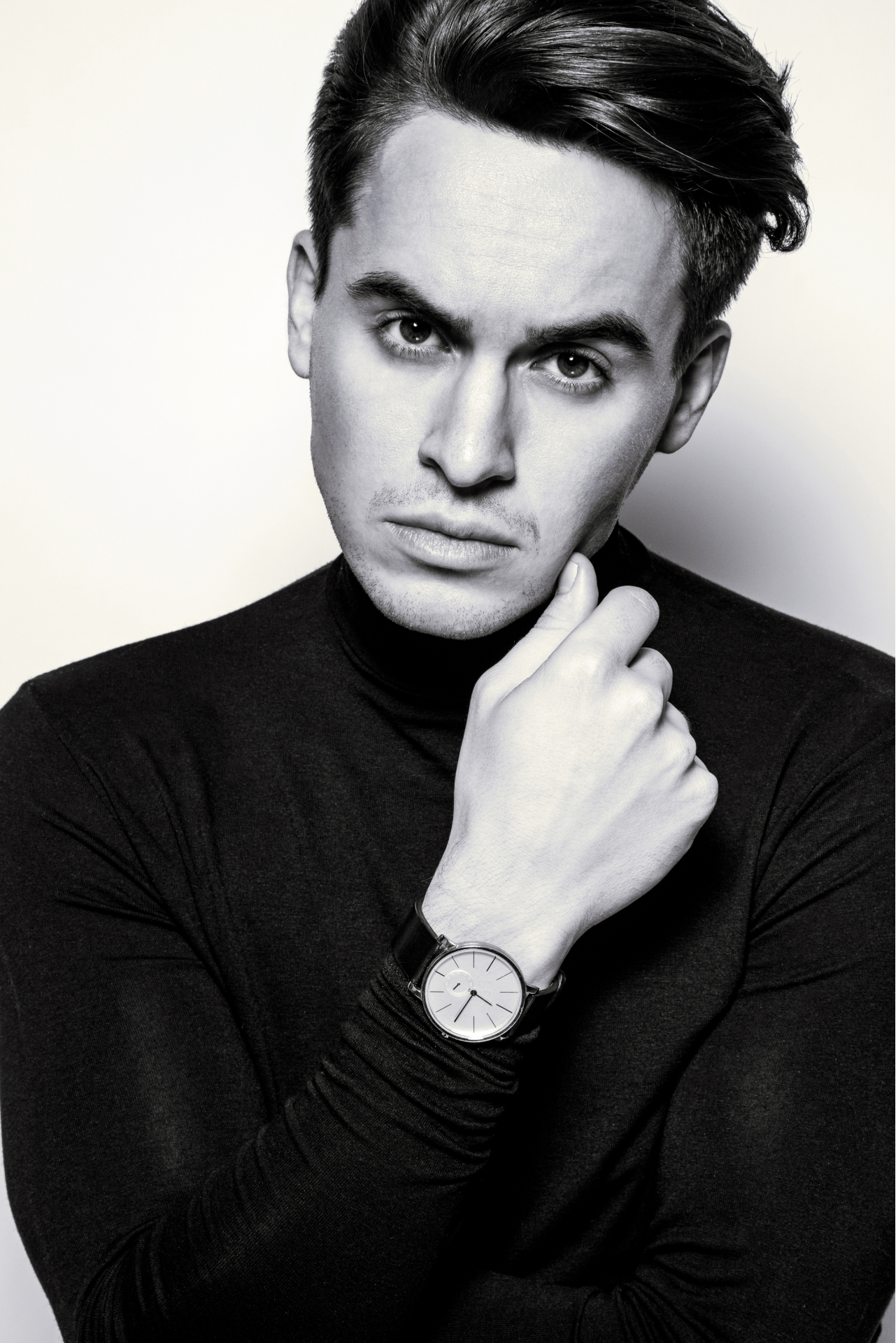A black and white photo of a man wearing a watch