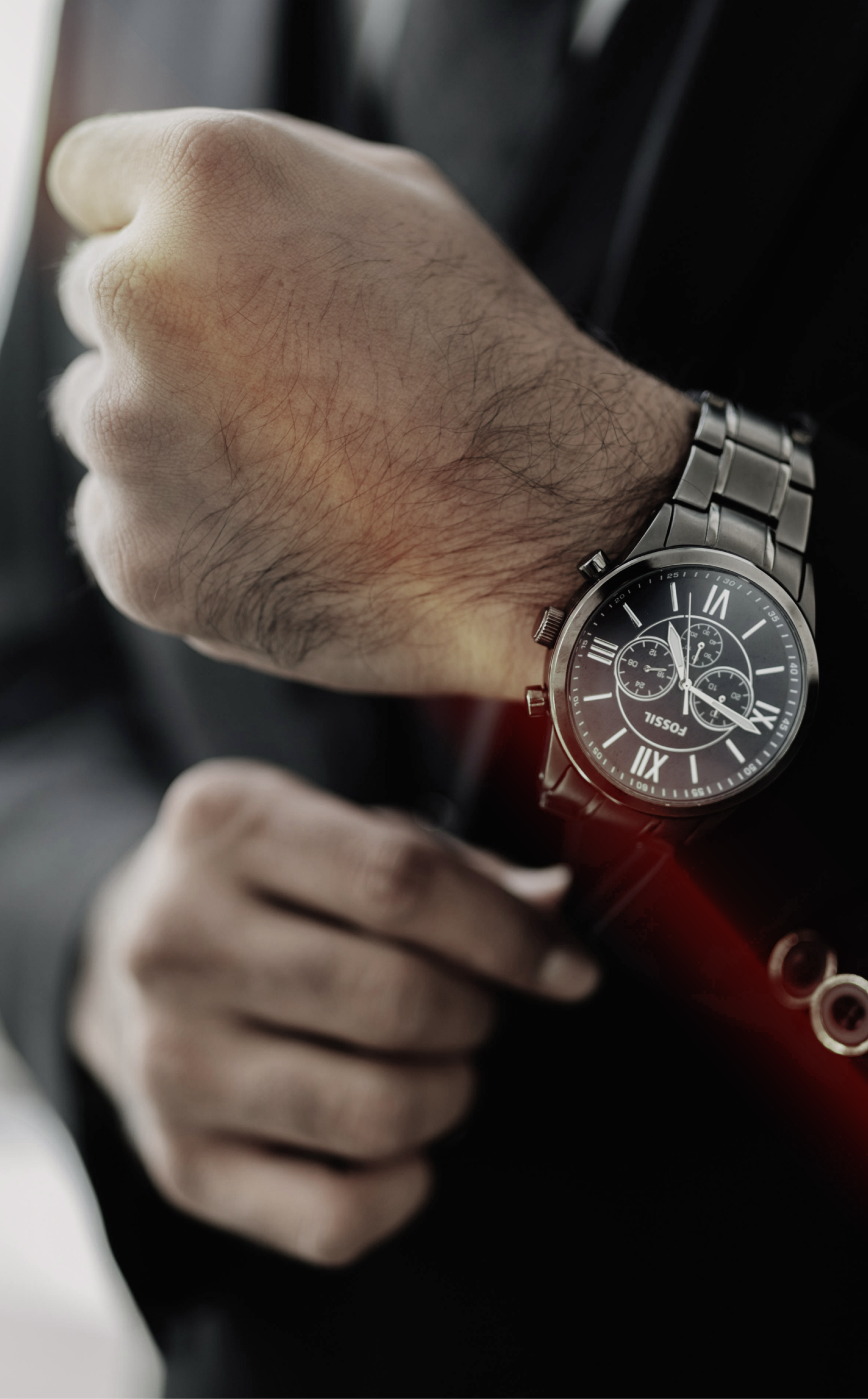 A man in a suit is looking at his watch