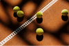 Drei Tennisbälle liegen auf einem Tennisplatz