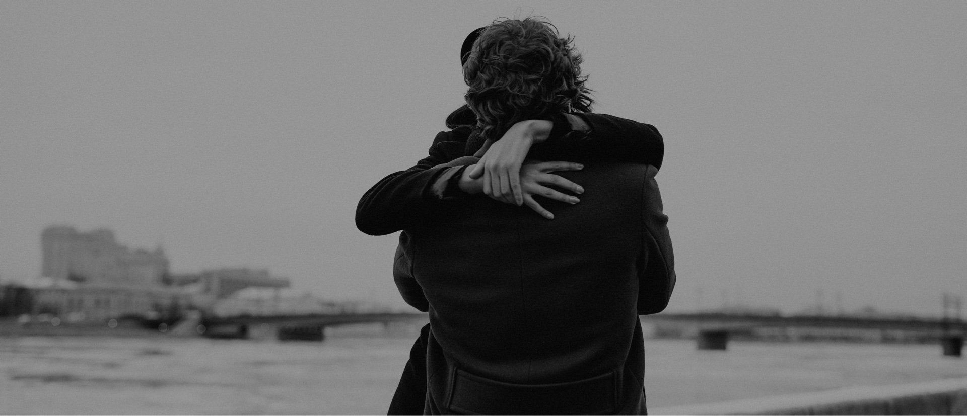 A black and white photo of a man and woman hugging each other.