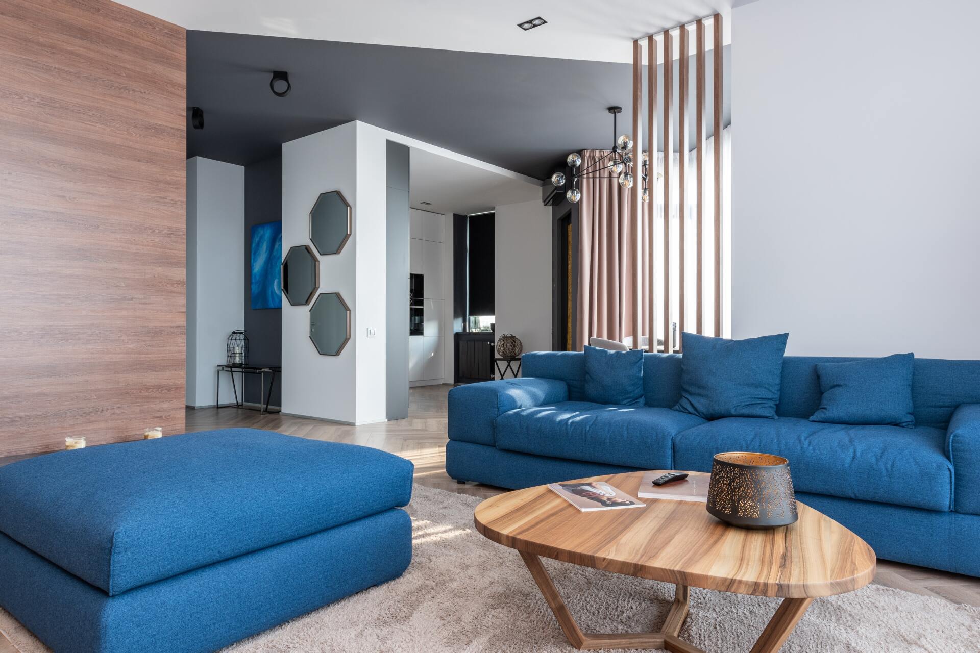 A living room with blue furniture and a wooden coffee table.