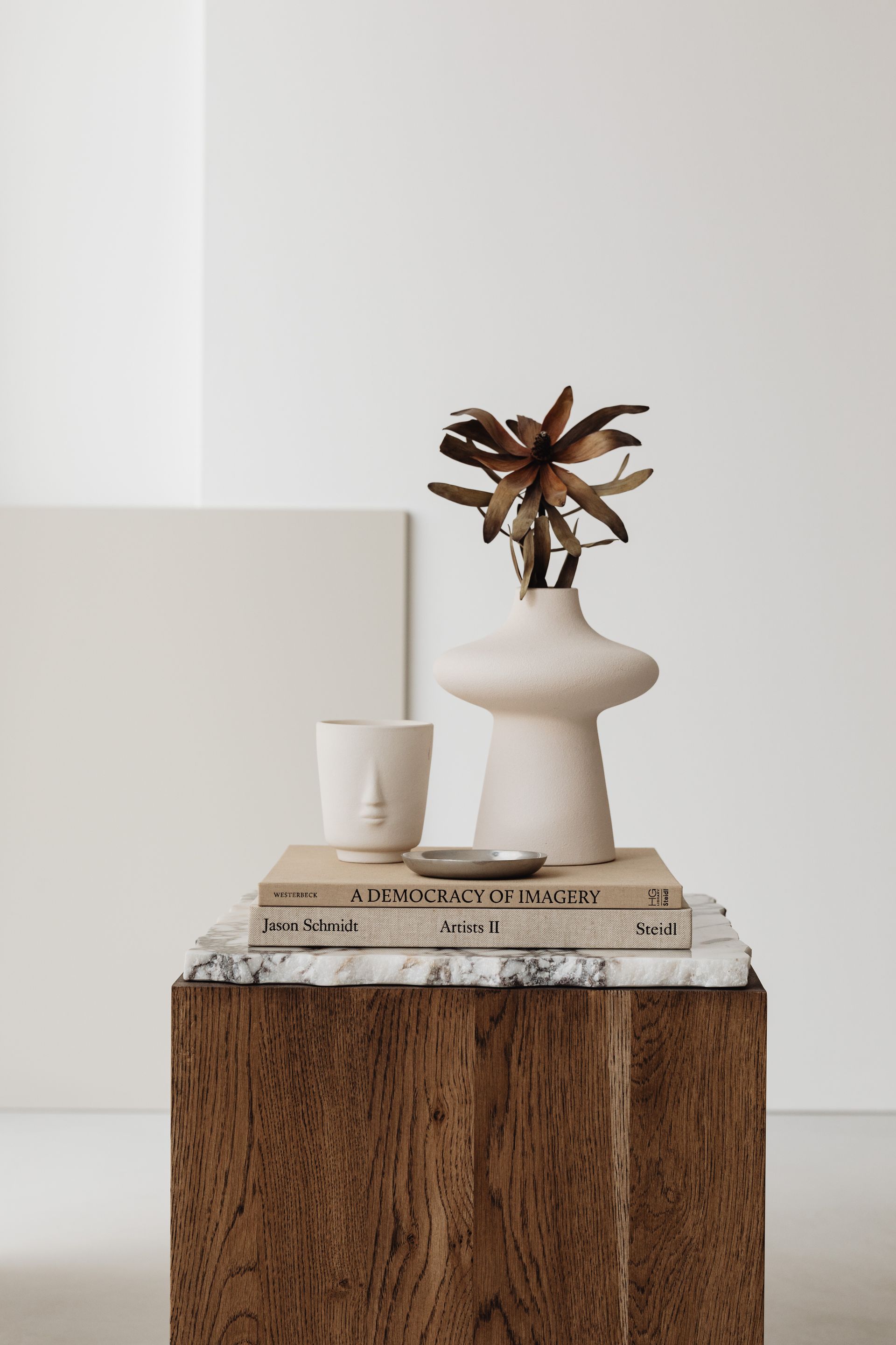 A vase with a plant in it is sitting on top of a wooden table.
