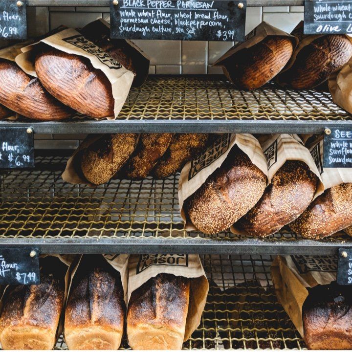 Several loaves of bread are on display in a bakery