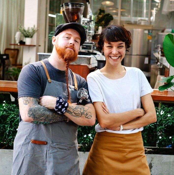 A man and a woman standing next to each other with their arms crossed