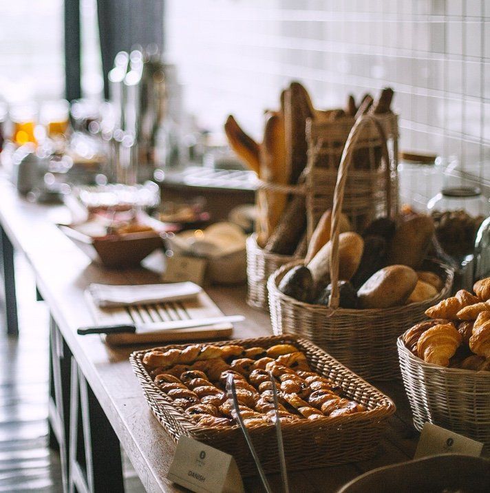 A table with baskets of bread and croissants on it