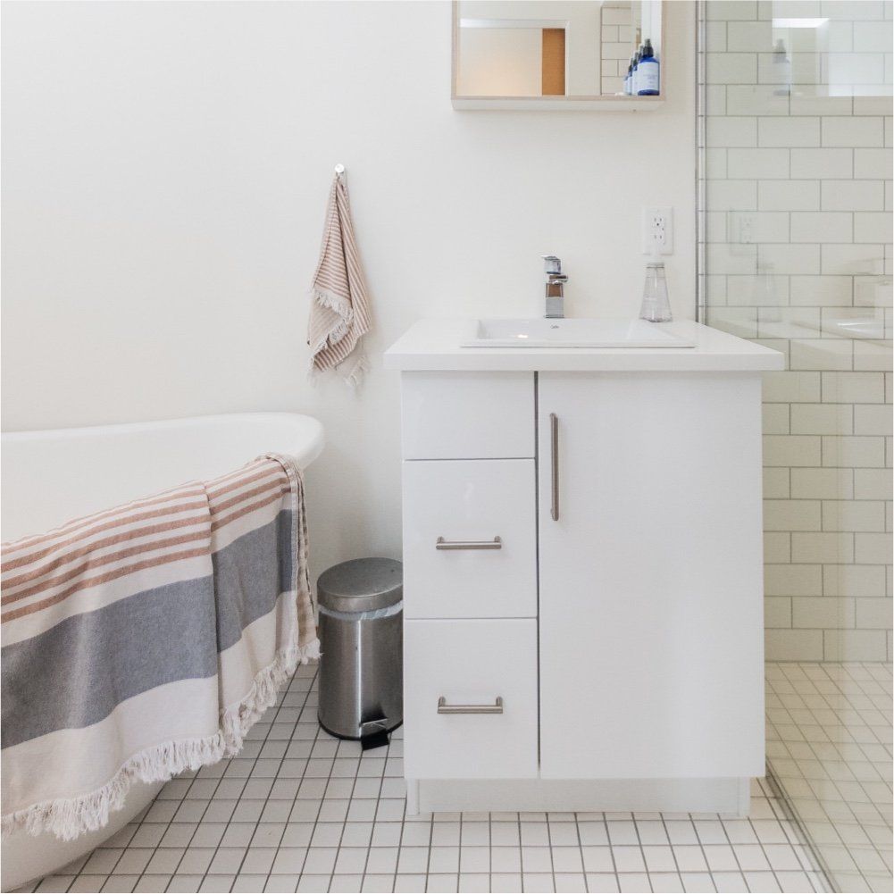 Een badkamer met ligbad, wastafel en prullenbak