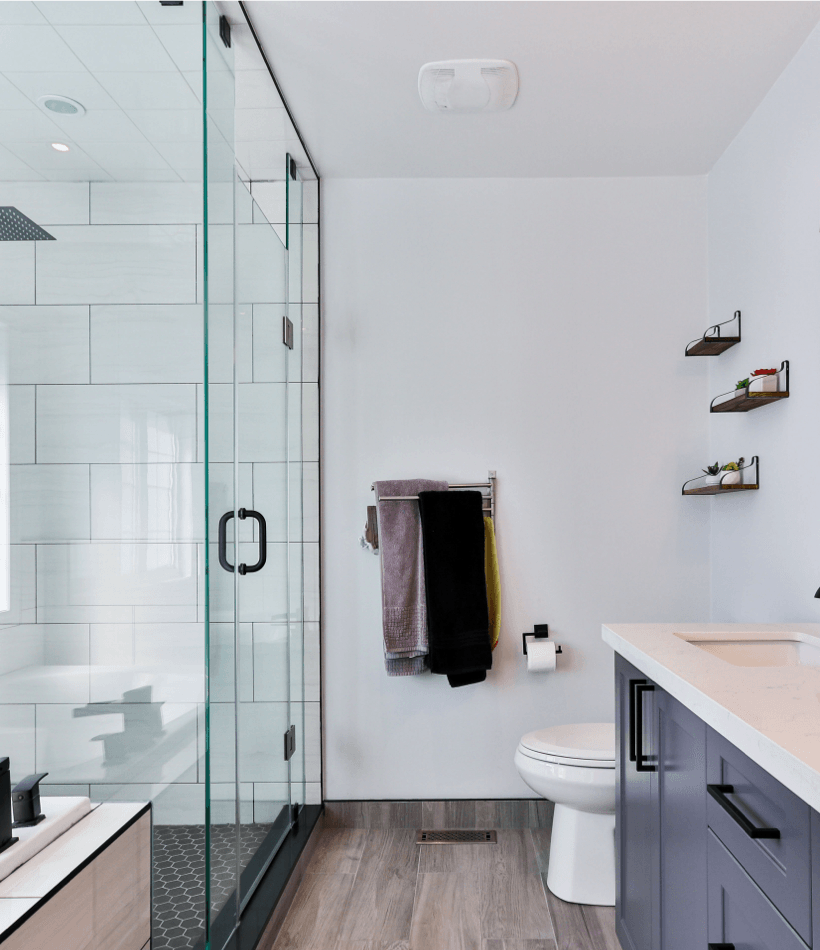 Modern bathroom with sliding glass shower door and freshly painted white walls along with sink with granite countertop