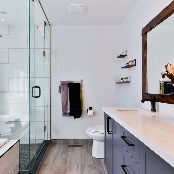 bathroom with hardwood floors and walk-in shower after property restoration