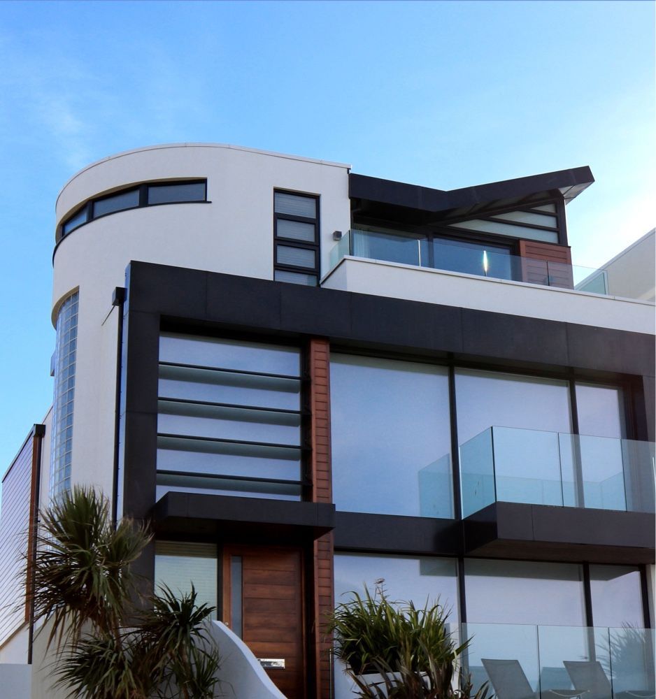 A large white and black house with a balcony