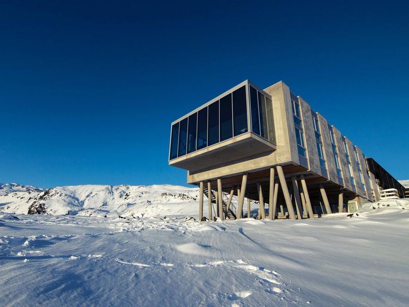 A large building is sitting in the middle of a snow covered field.