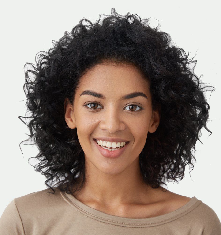A woman with curly hair is smiling for the camera