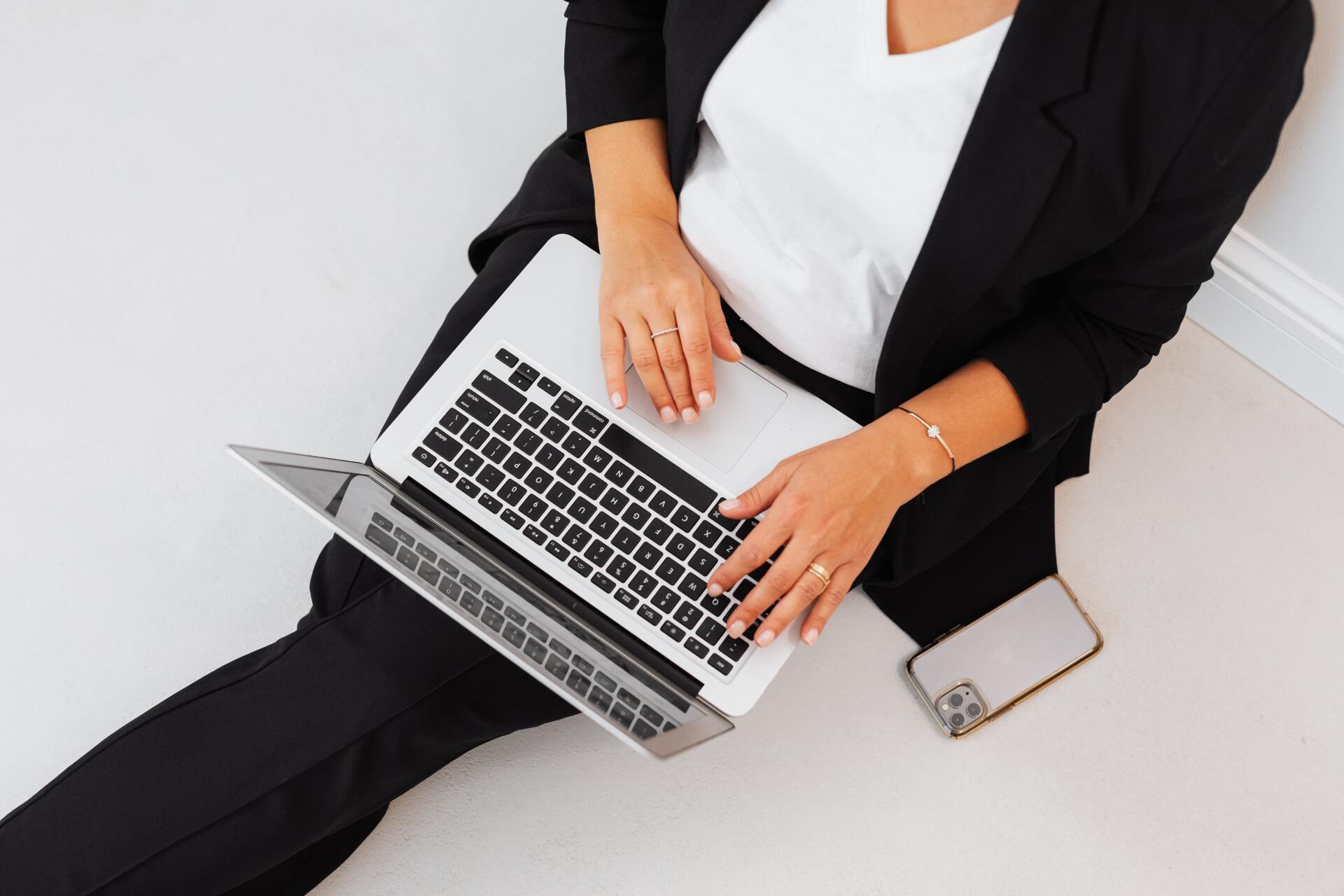 a woman is sitting on the floor using a laptop computer .