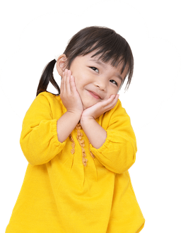 Young girl with dark hair, smiling, hands on cheeks, wearing a yellow sweater.