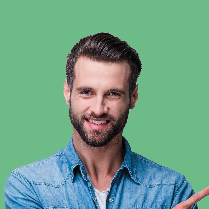 A man with a beard is smiling and pointing to the side.