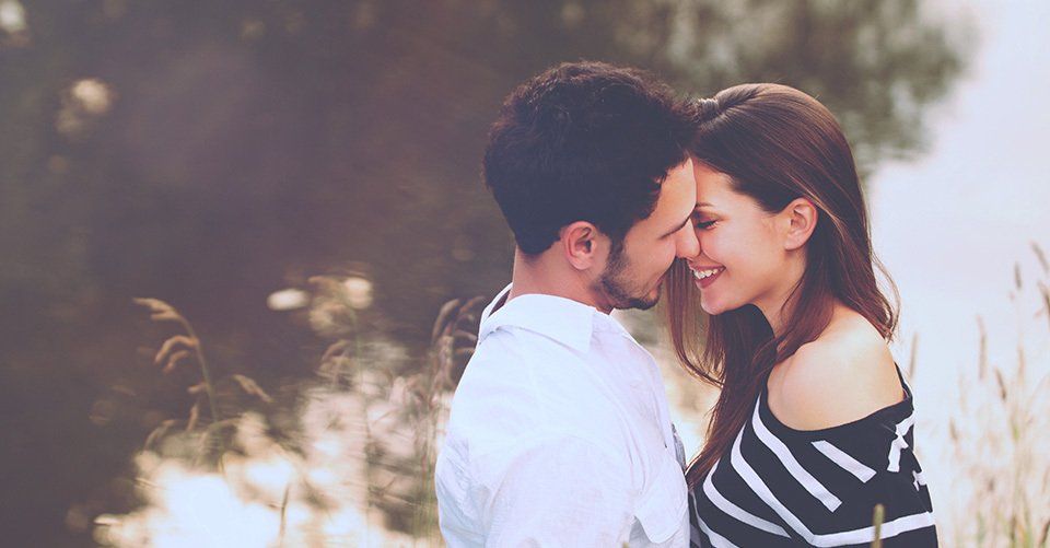 A man and a woman are looking at each other in a field.