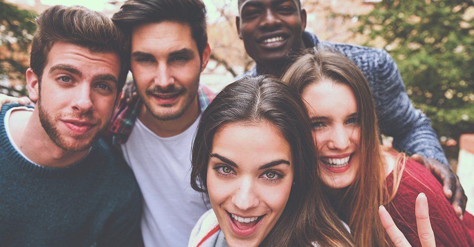 A group of young people are posing for a picture together.