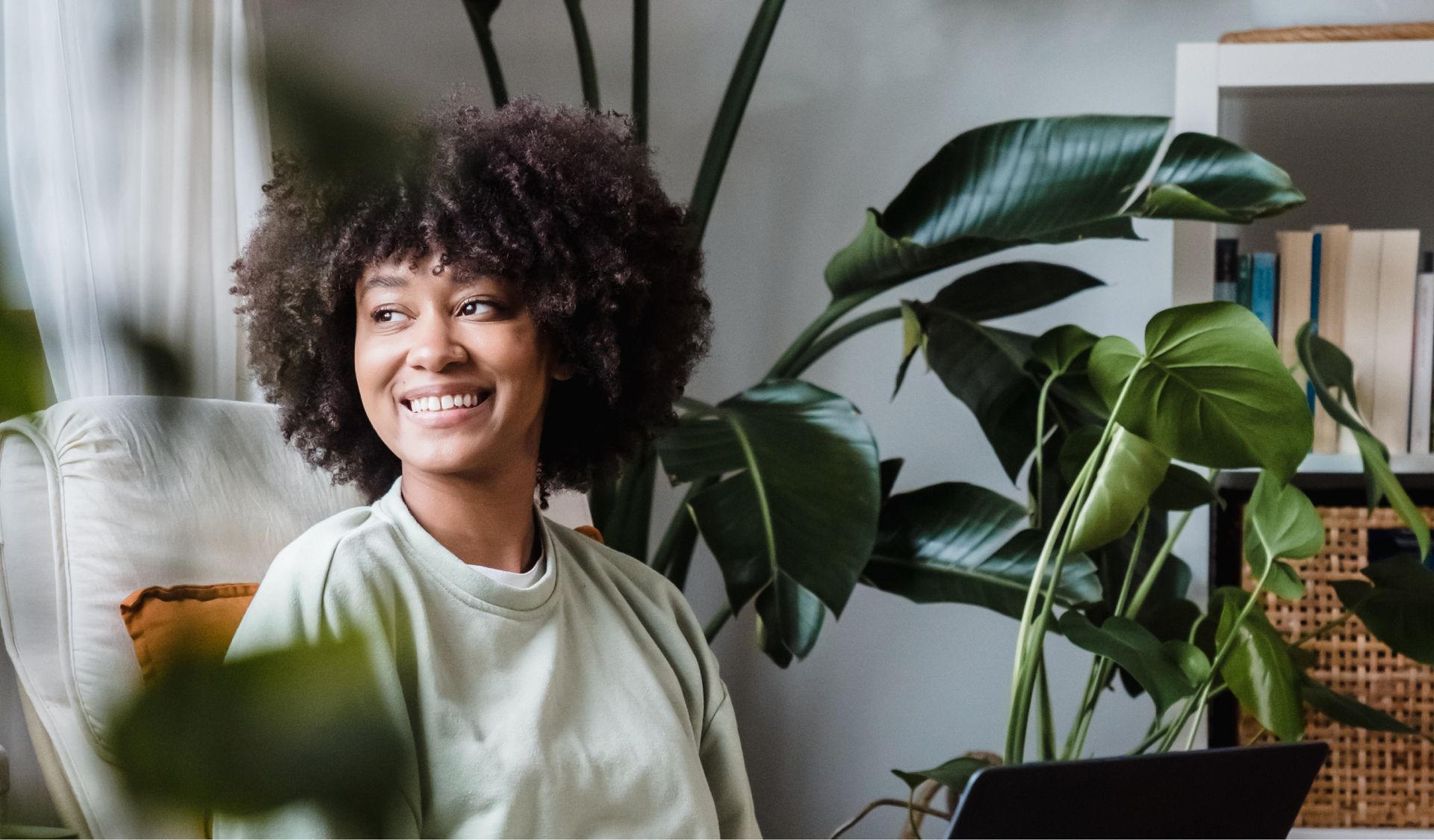 Man in a black vest smiles at the camera, in an office setting.