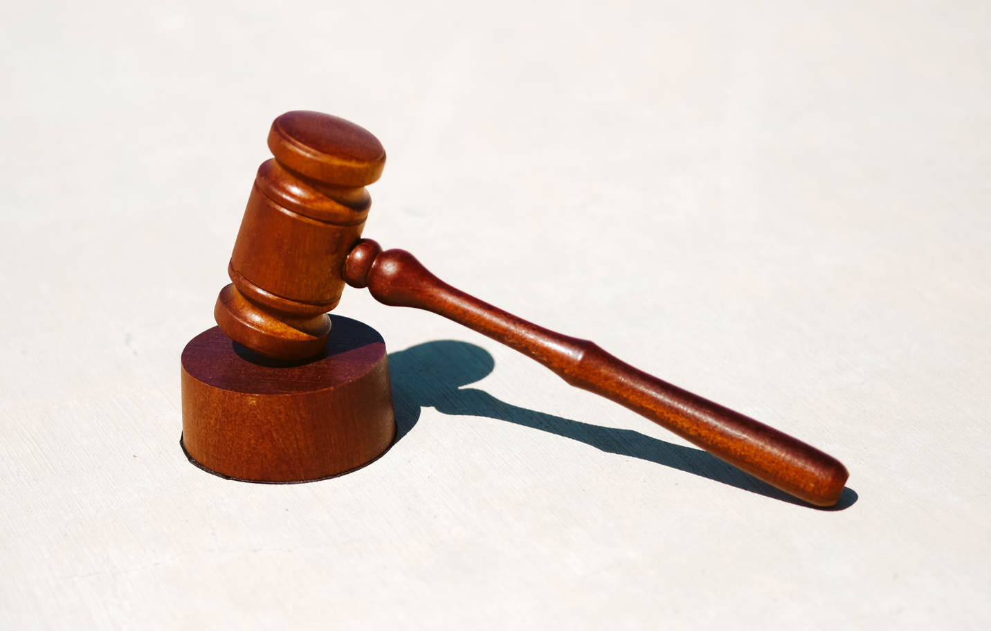 A wooden judge 's gavel is sitting on a white surface