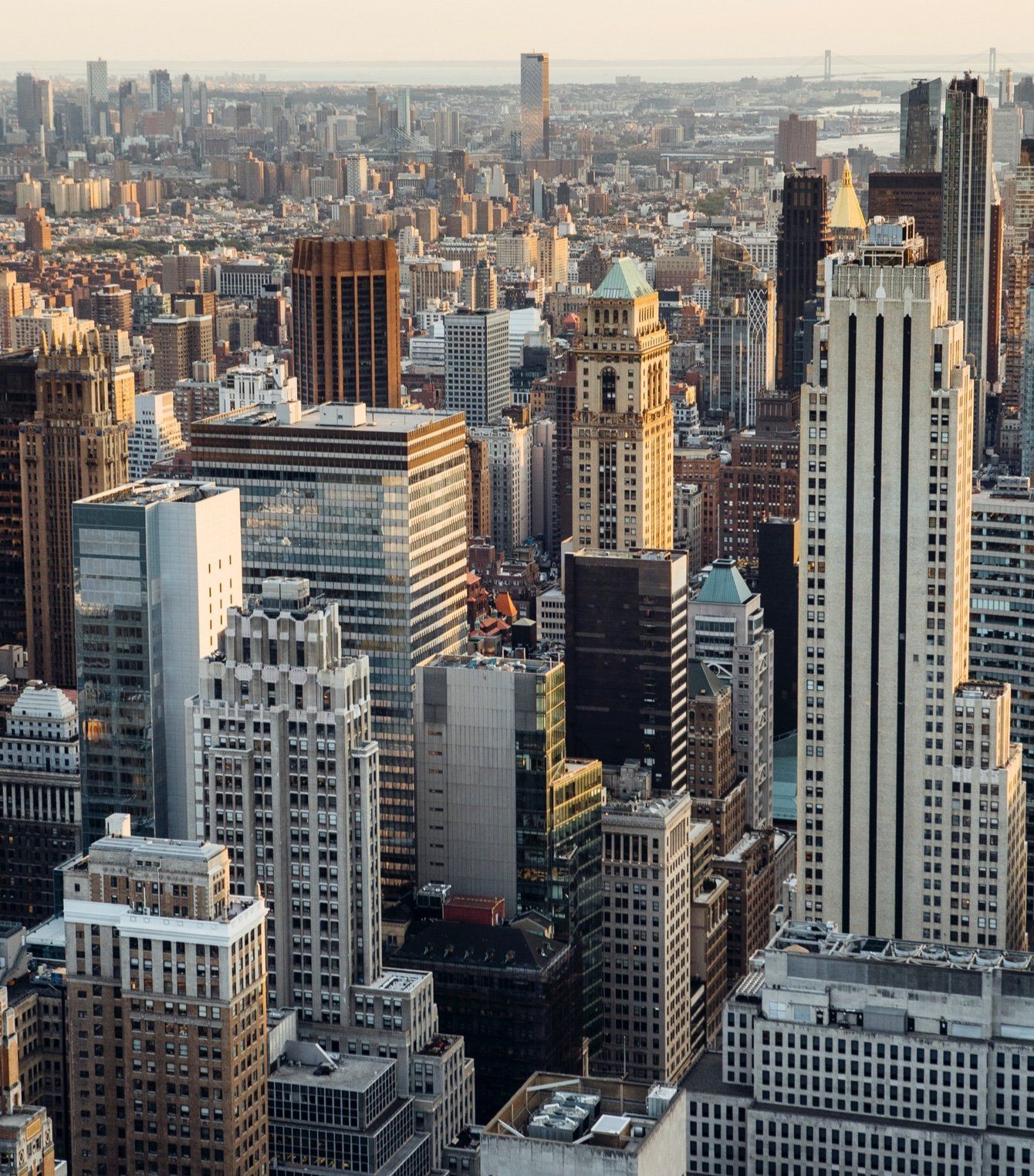 City skyline with various tall buildings under a hazy sky.