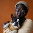 Un homme tient un chien noir et blanc dans ses bras.