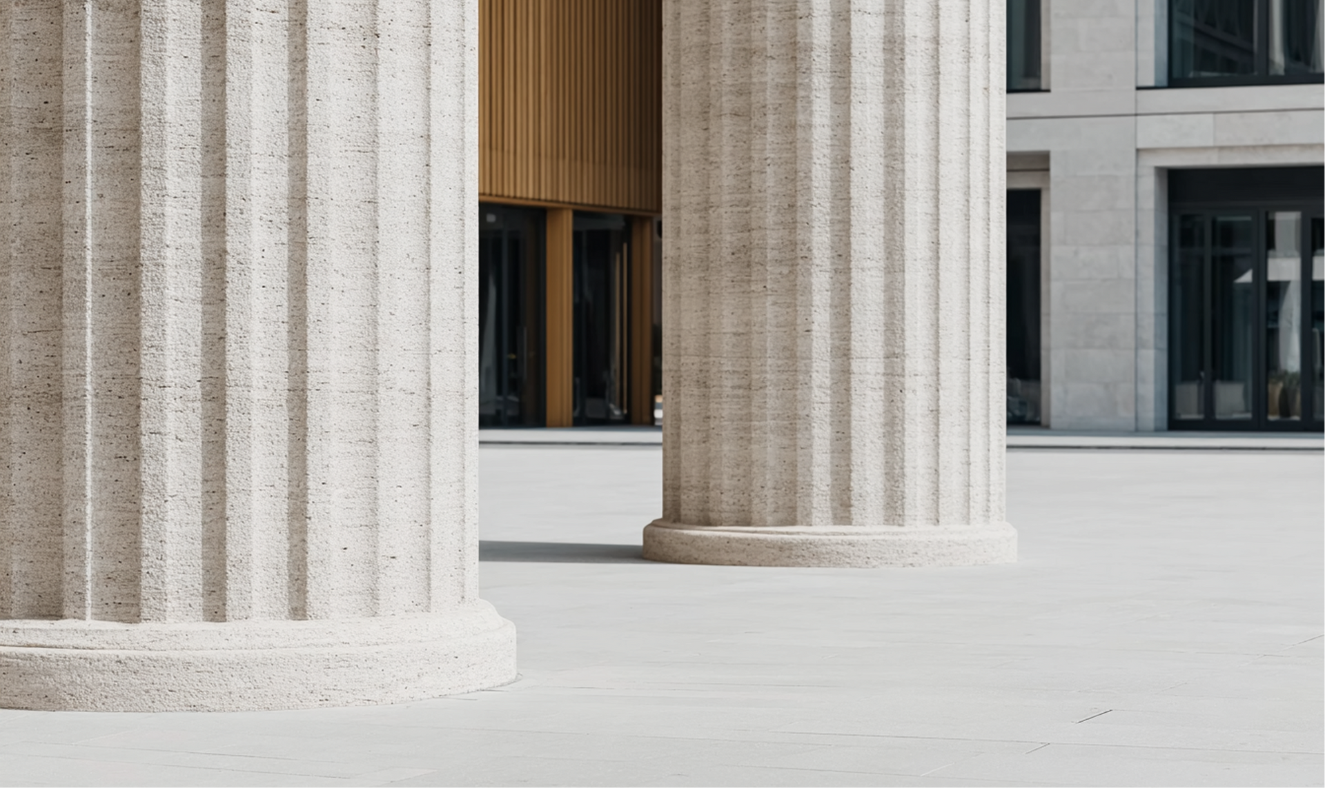 Two fluted, light-colored columns in a plaza, building in the background.
