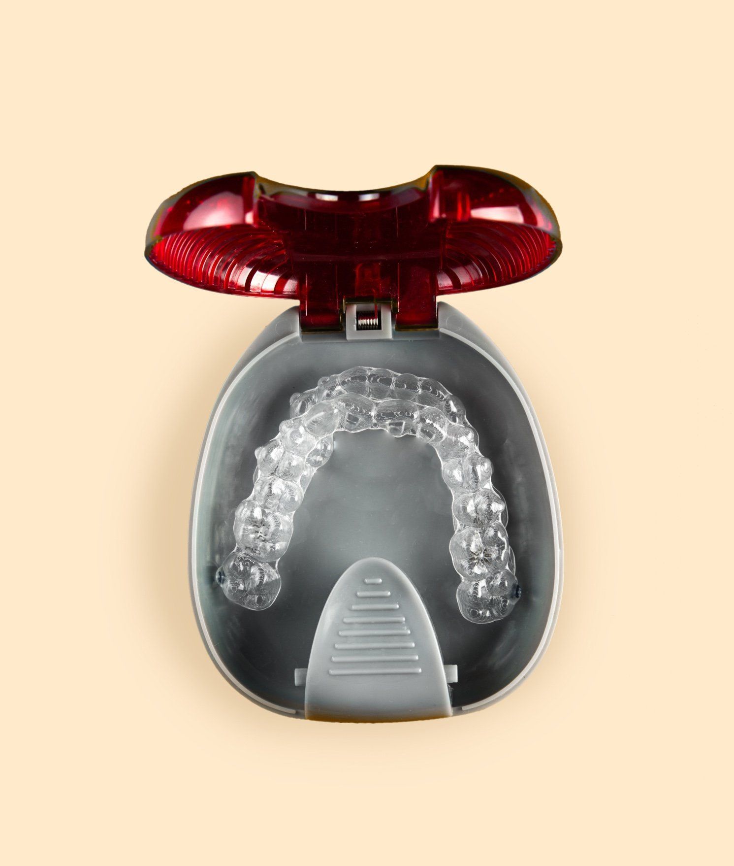 Clear dental aligner in an open, red-lidded storage case.