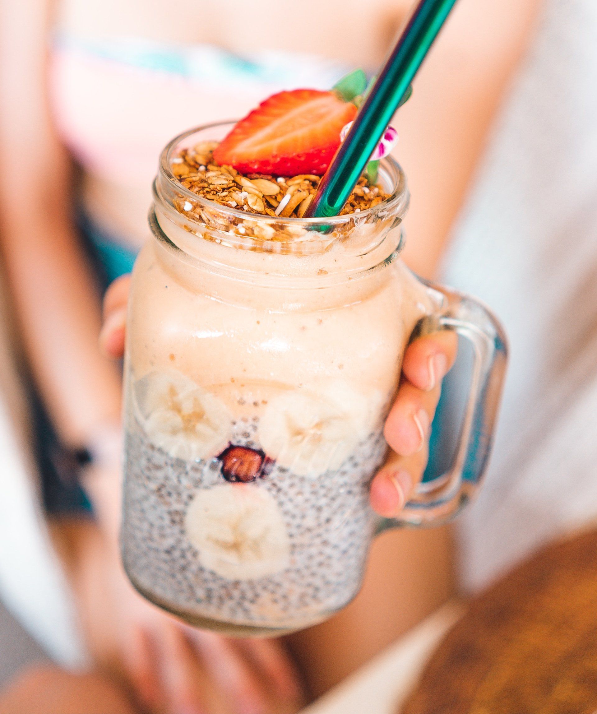 Una persona sostiene un batido en un frasco con una pajita