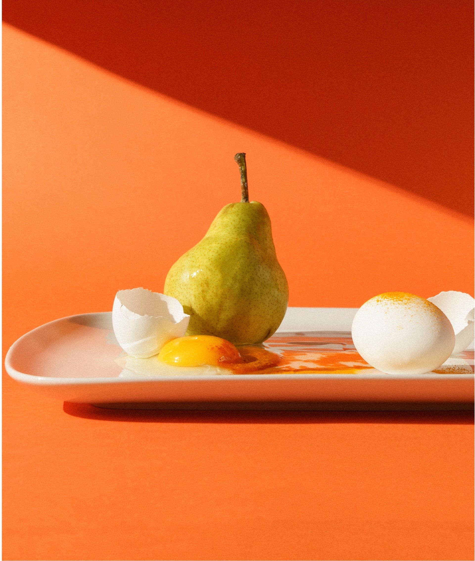 Un plato blanco con huevos y una pera
