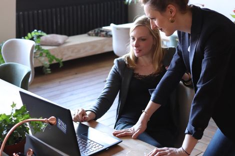 Business colleagues in a meeting around a table, reviewing documents, discussing findings of financial investigations.