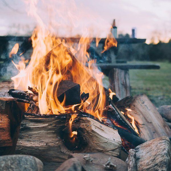 Campfire with logs burning, outdoor camping experience at The Ridge at Flathead Lake.