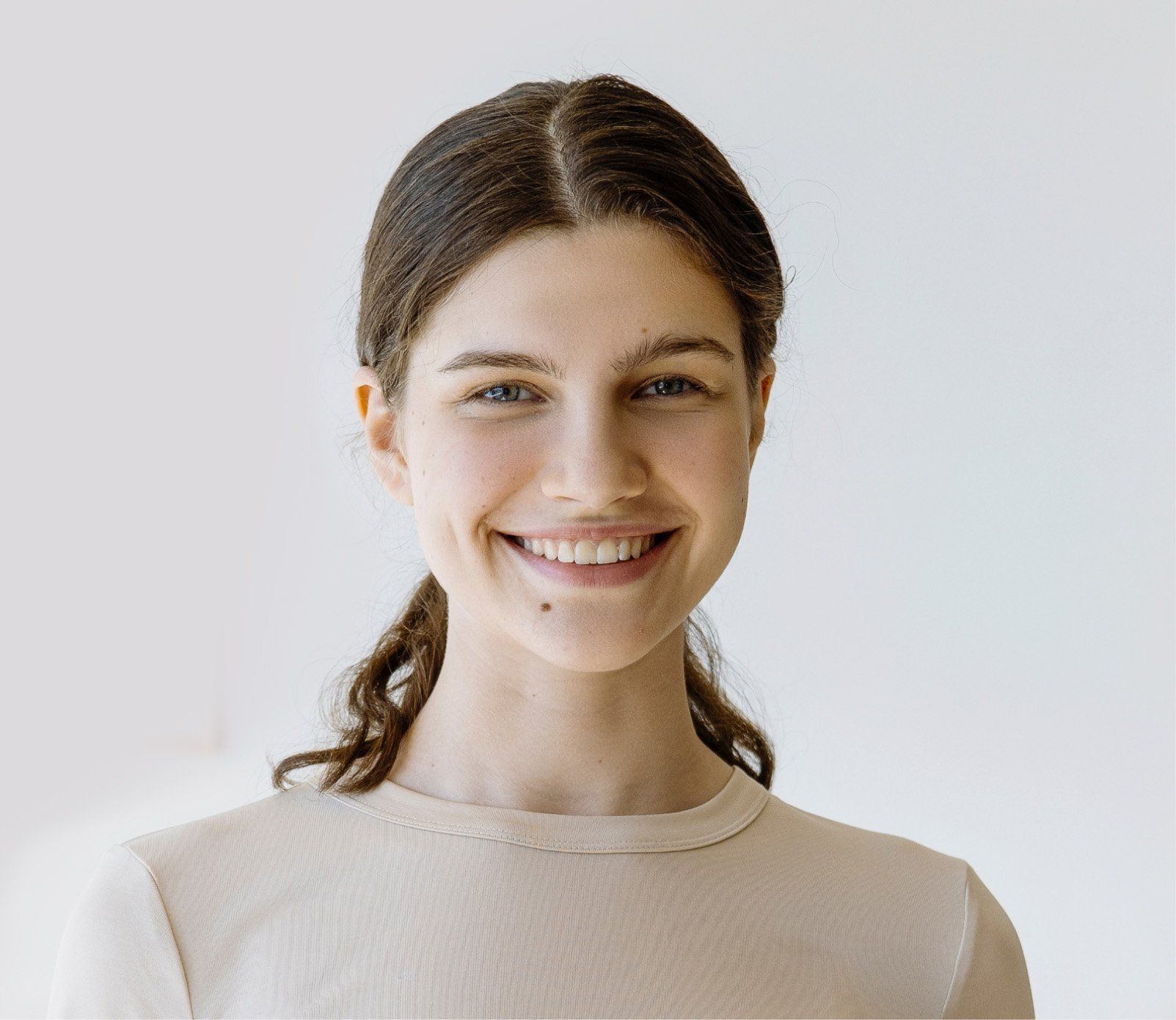 A woman in a white shirt is smiling for the camera.