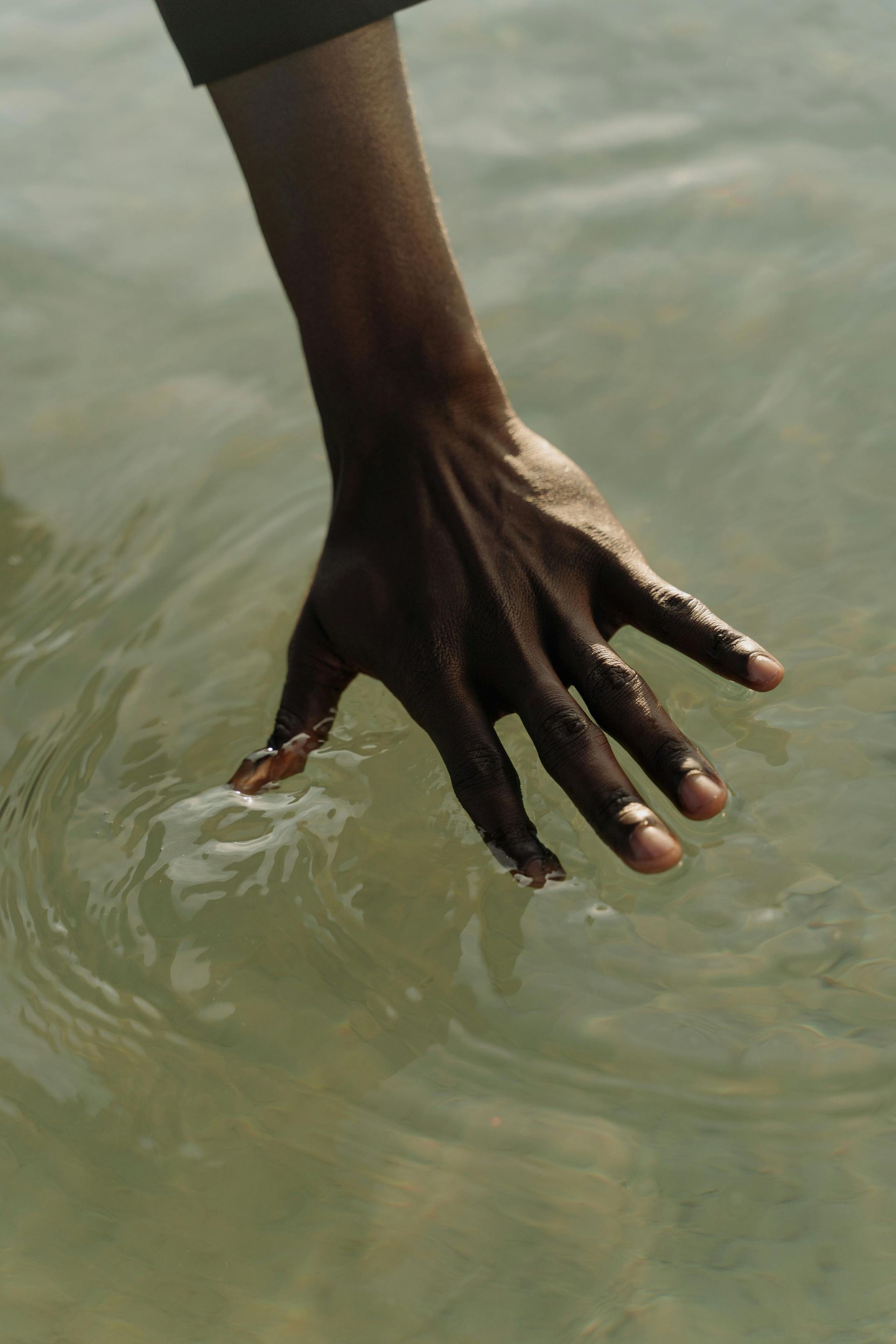 A close up of a person 's hand in the water.