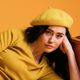 A woman wearing a yellow beret and a yellow shirt