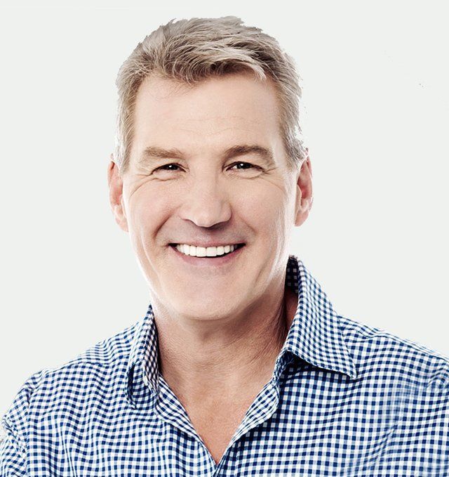 Smiling man in blue checkered shirt.