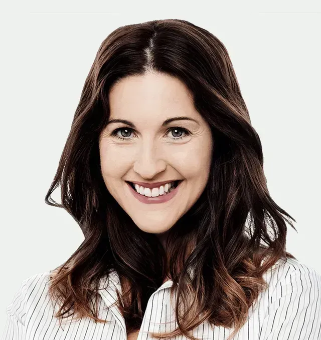 A woman with long brown hair is smiling and wearing a striped shirt