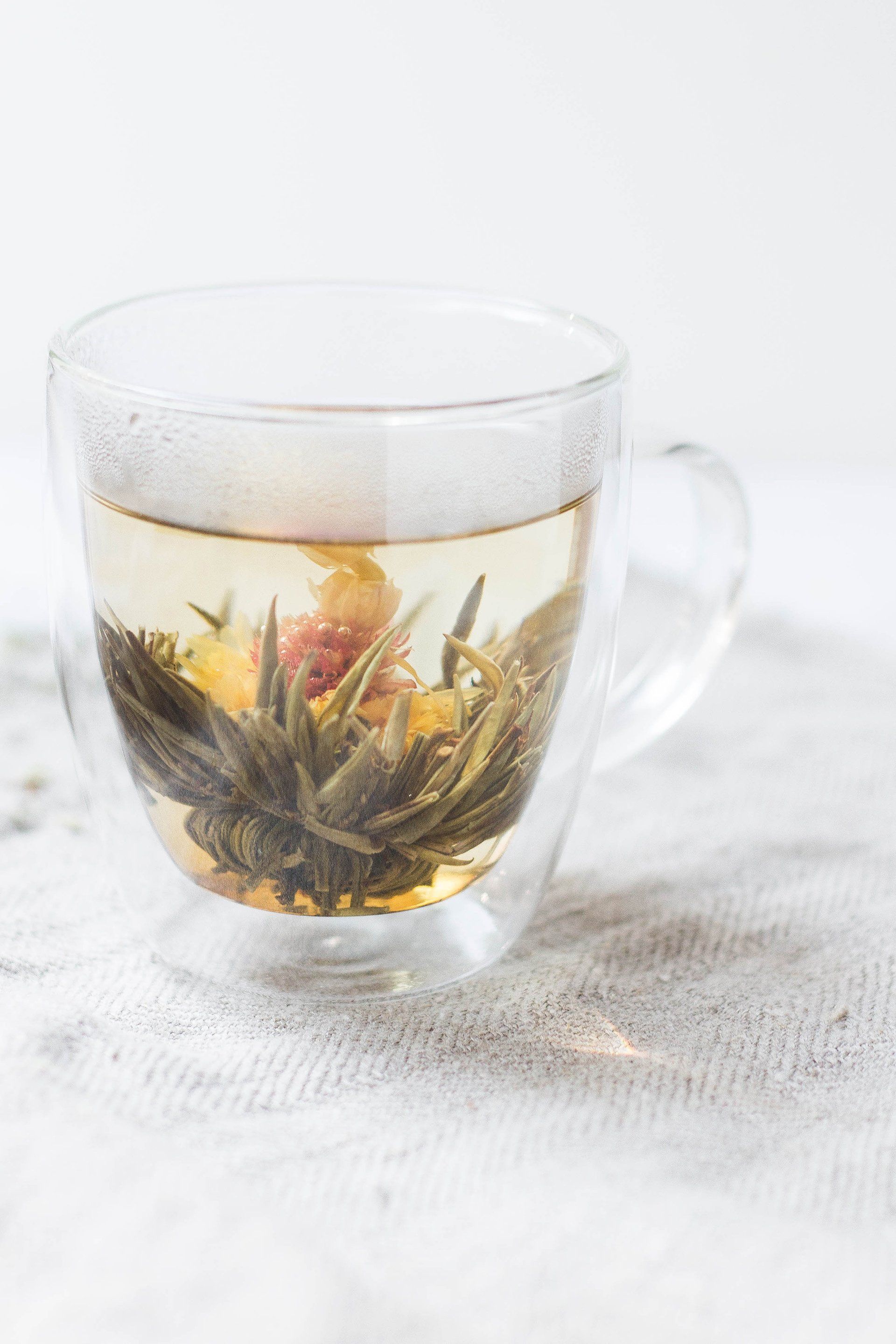 A cup of tea with flowers in it on a table.