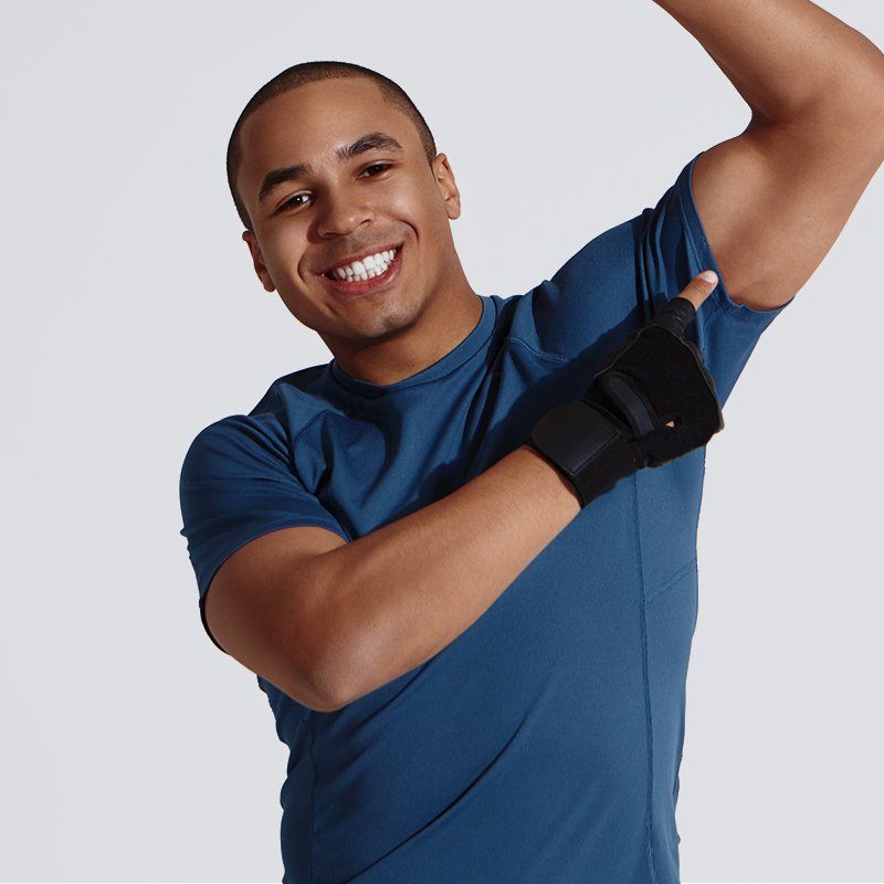 A man wearing a blue shirt and black gloves is smiling