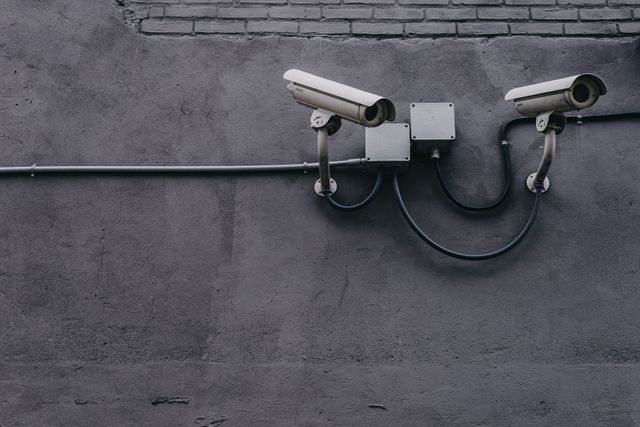 Two security cameras are mounted on the side of a building.