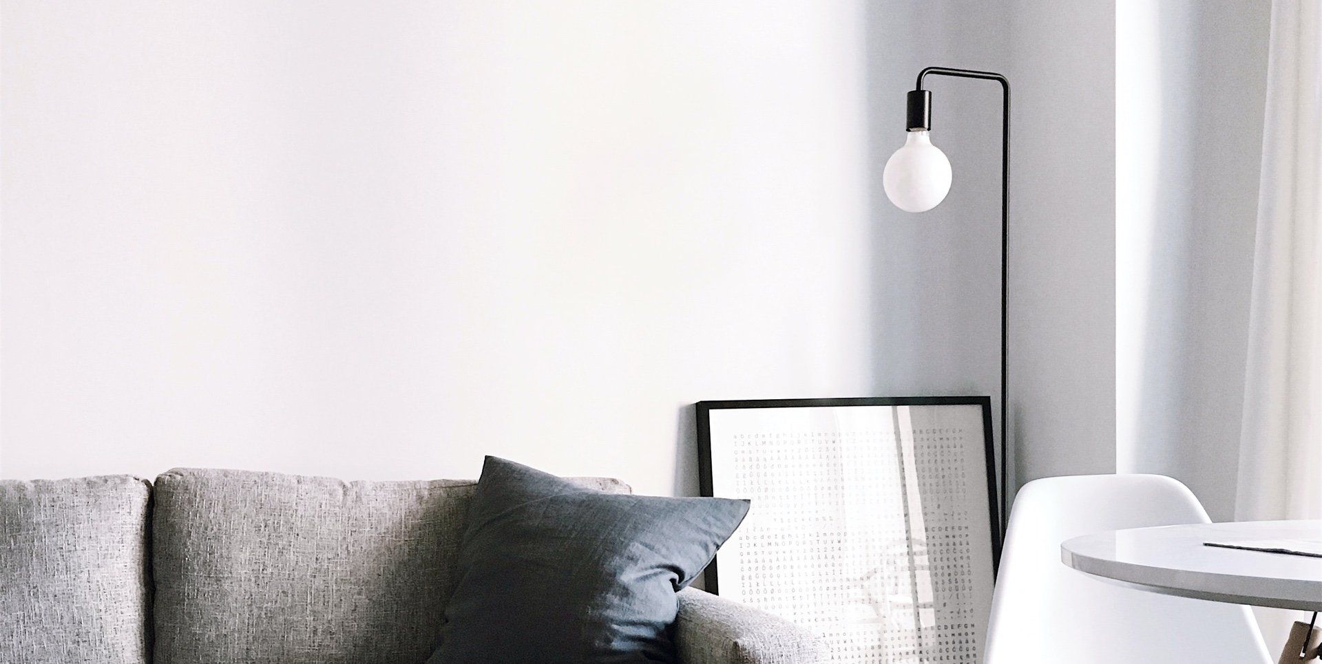 A living room with a couch , chair , table and lamp.