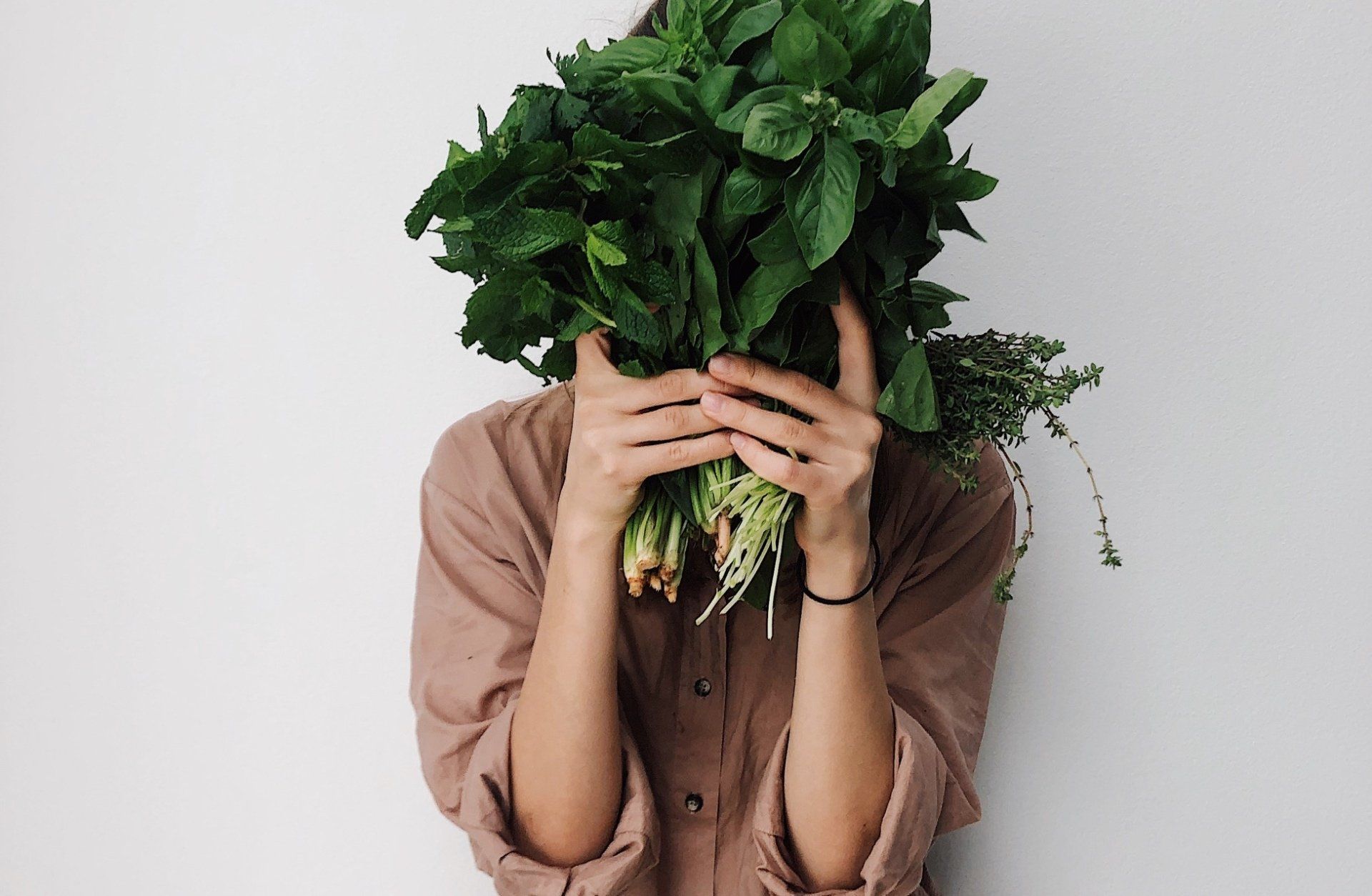 woman holding up fresh vegetables