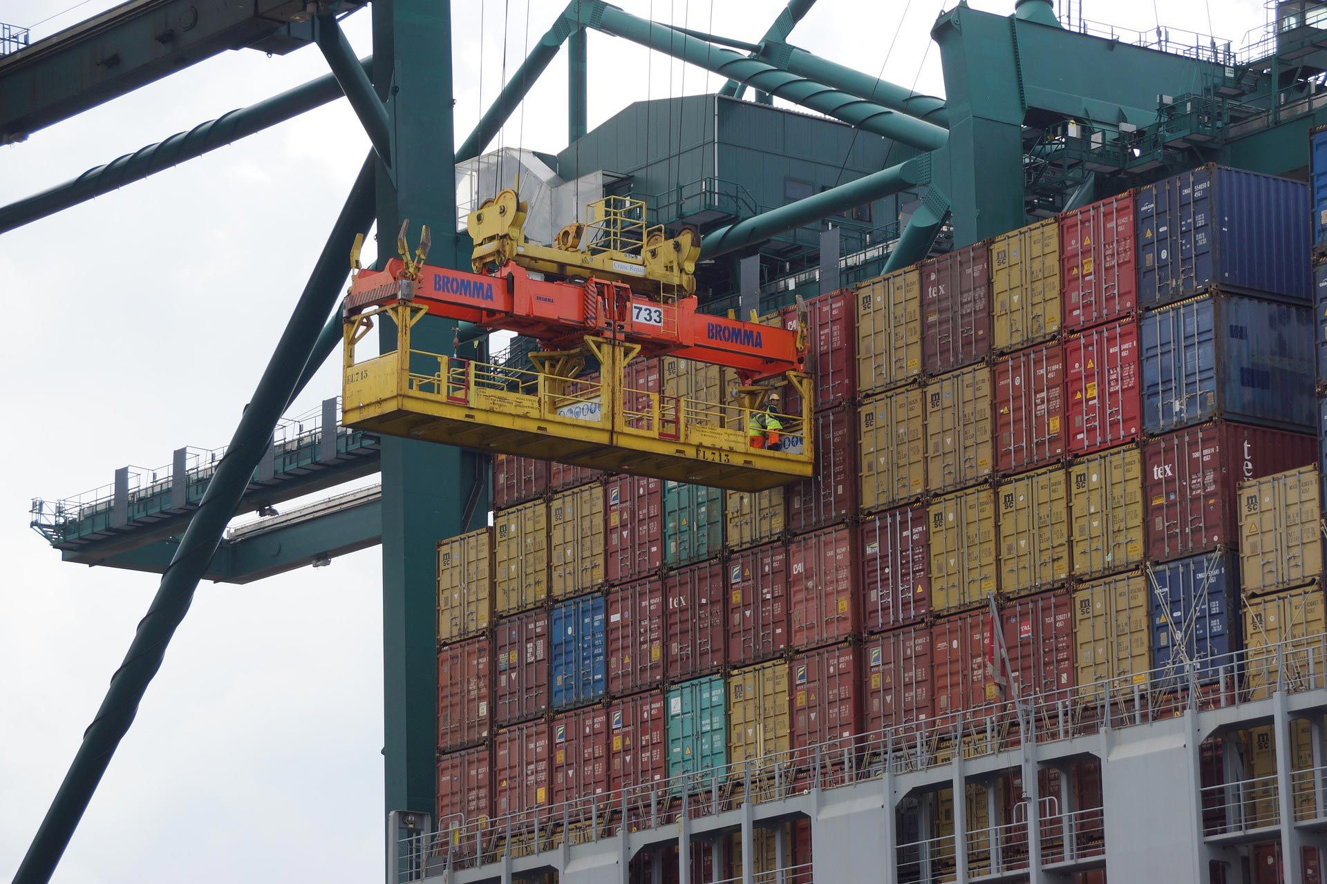 A large container ship is being loaded with cargo