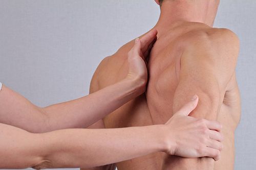 A woman is giving a man a massage on his back.