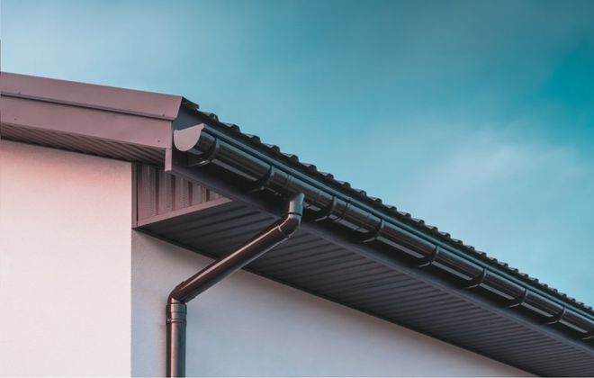 A close up of a gutter on the roof of a house.