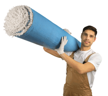 A man is carrying a large roll of carpet on his shoulders.