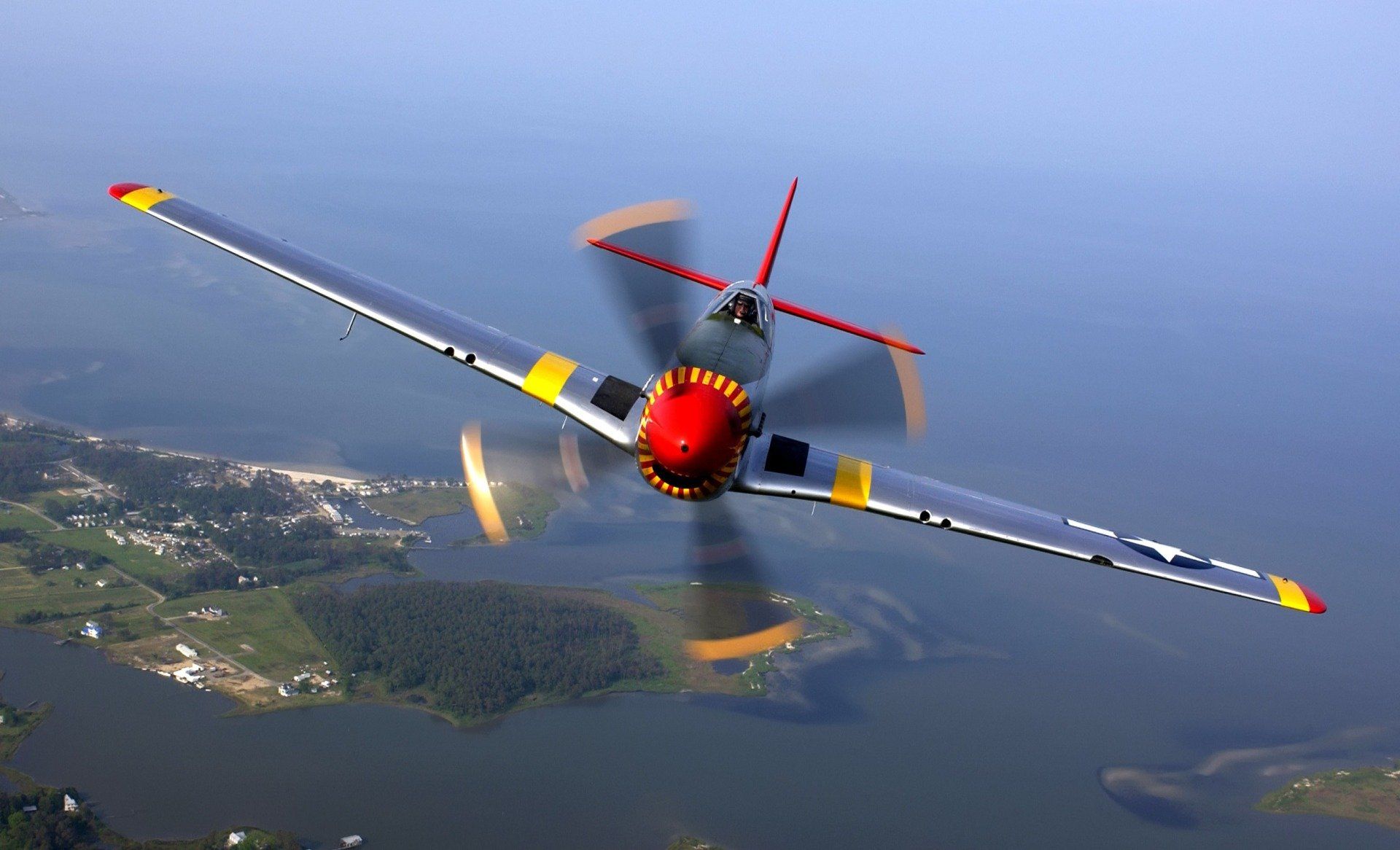 Pilot flying aerobatic plane with propellers