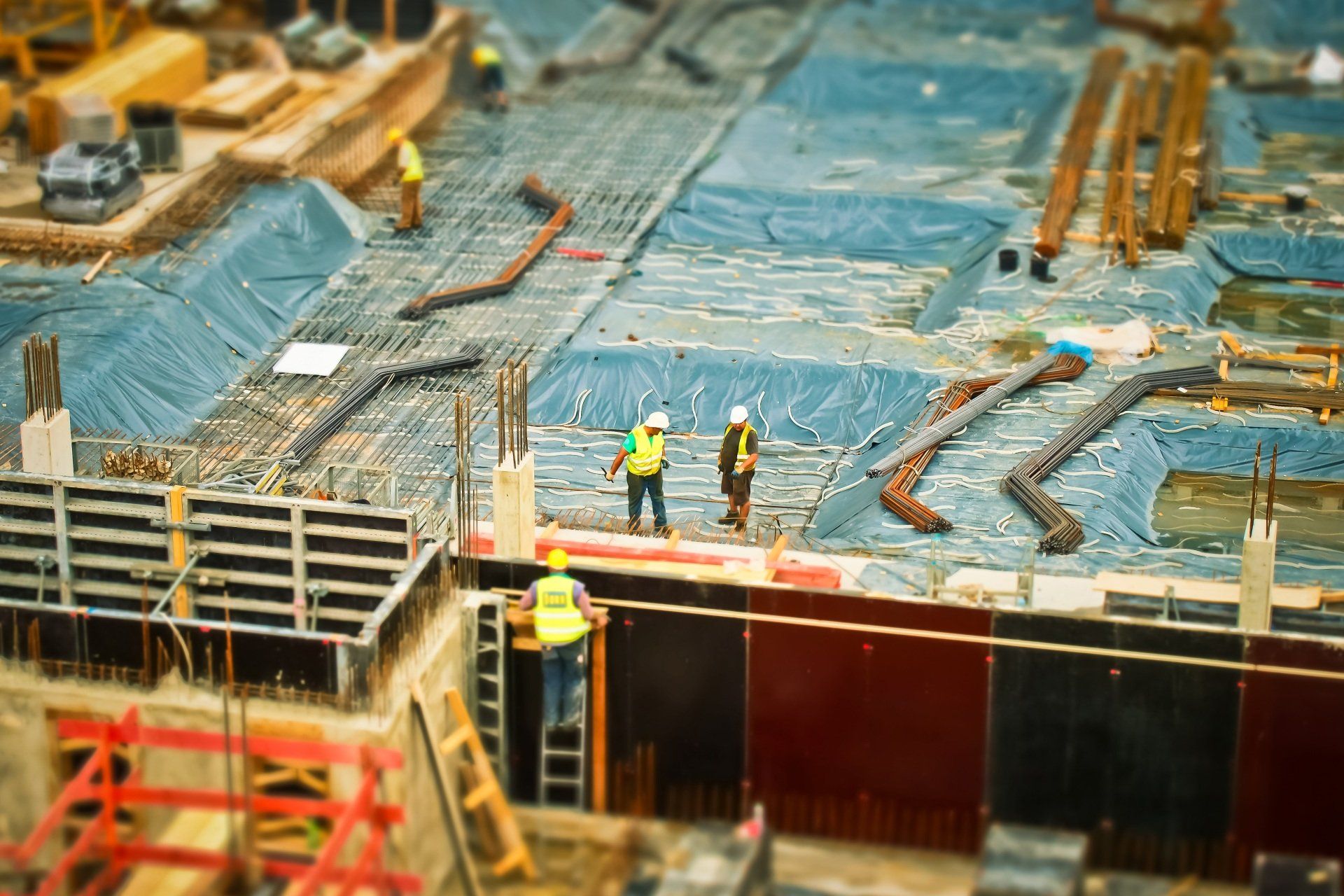 A group of construction workers are standing on top of a construction site.