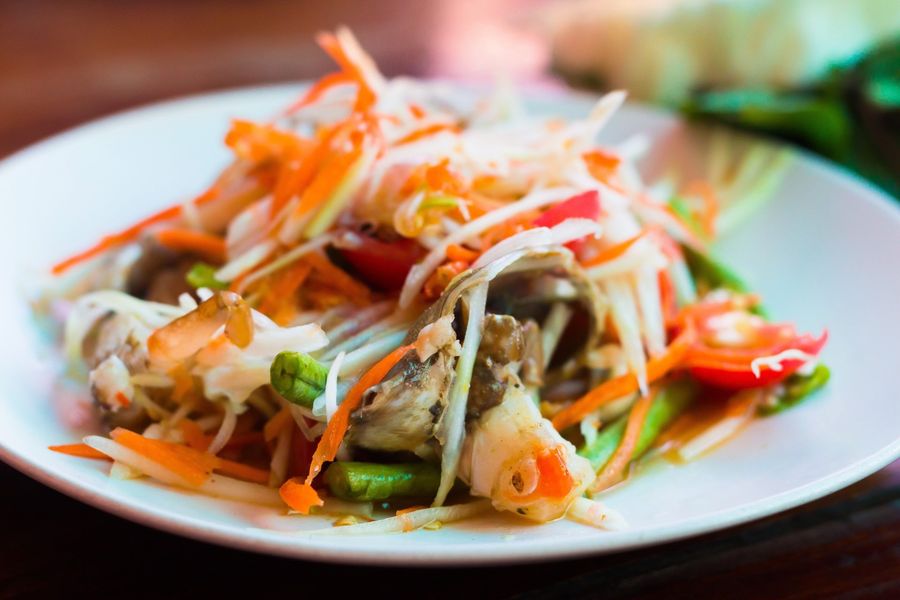 A close up of a plate of food with vegetables on a table.